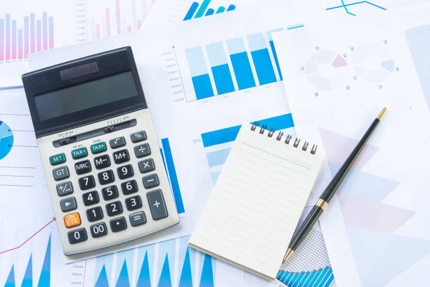 istock Calculator and Pen with Business Graphs finance document. 1036601446