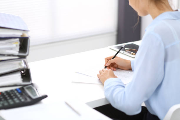 istock Unknown female bookkeeper or financial inspector calculating or checking balance, making report, close-up. Internal Revenue Service at work with financial document. Tax and audit concept. 1036606152