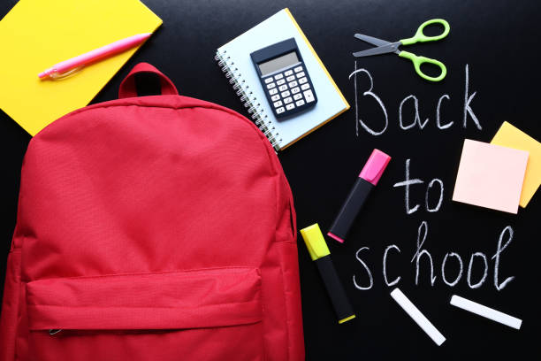 istock Red backpack with school supplies on black chalkboard 1036609216