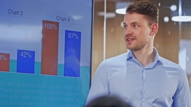 Caucasian man holding a presentation in the glass conference room