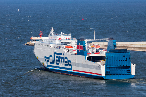 Swinoujscie, Poland - July 20, 2018: Baltic Sea Ferry Cracovia slowly leaving the Swinoujscie harbor. Unity Line is a Polish company that operates RoRo and train ferry services between Świnoujście in Poland and the Swedish ports of Ystad and Trelleborg