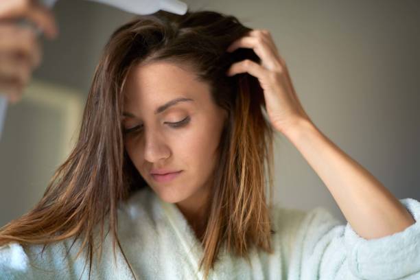 istock Woman with hair dryer 1036619972