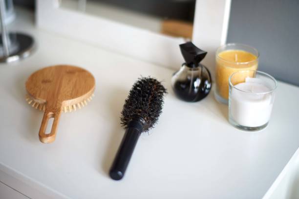 Close up view of hair brushes, perfume and candles  in the bathroom.