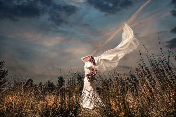 istock Bride with a bouquest in windy garden 1036620830