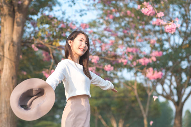 istock Young woman with smiling under cherry blossom in garden. Springtime 1036621352