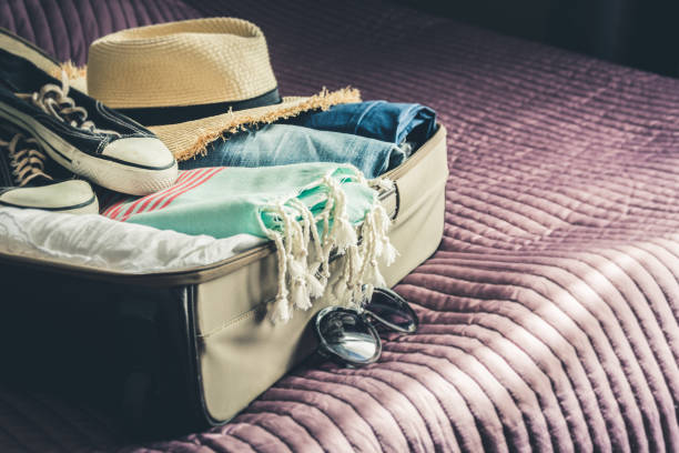 istock Open suitcase with female clothes for beach vacation. 1036625602