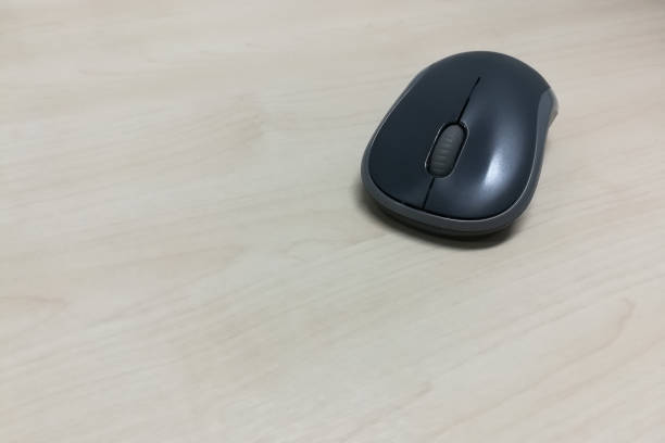 istock Black color computer mouse on the wooden table with copy space 1036625680