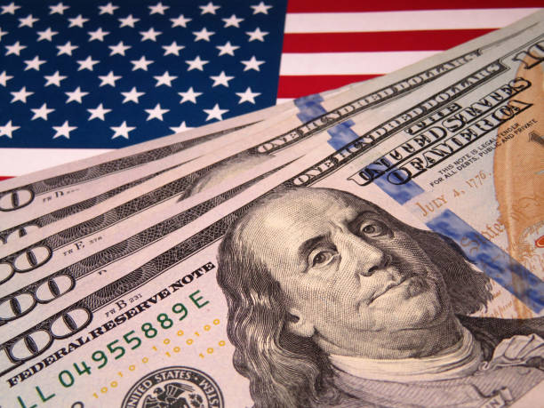 istock US dollars on background of US national flag 1036627570