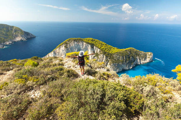 frau stehend arme ausgestreckt und beobachten in sicht - backpacker green vacations outdoors stock-fotos und bilder