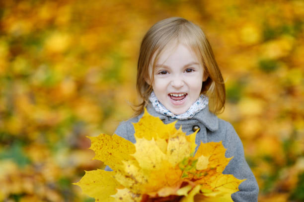Adorable girl having fun on beautiful autumn day