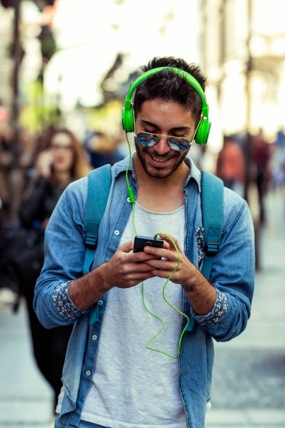 istock Smiling man texting and listening music 1036661050