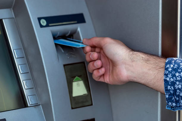 istock Young man put his credit card at the ATM 1036661492