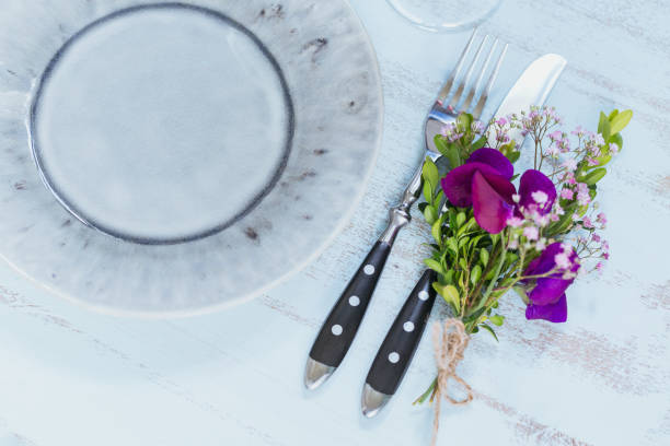 istock Rustic table setting with purple flowers on light wooden table. 1036665122