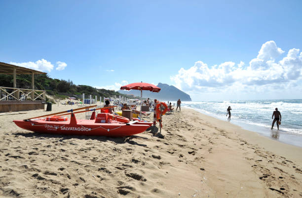 Relaxed people on the Sabaudia beach for the summer holidays. The Circeo Mountain on the background. Sabaudia, Lazio, Italy. Sabaudia, Lazio, Italy - SEPTEMBER 19, 2017 - Relaxed people on the Sabaudia beach for the summer holidays. The Circeo Mountain on the background. sabaudia stock pictures, royalty-free photos & images