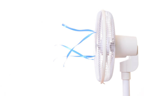Man hit by hot flush, sitting exhausted under electric fan