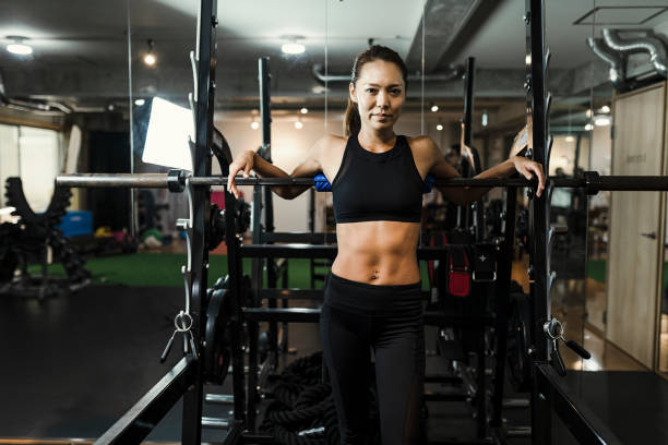 mujer adulta media de entrenamiento en el gimnasio - body care asian ethnicity body building toughness fotografías e imágenes de stock