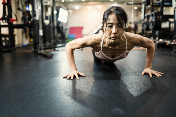 mujeres maduras trabajando en cruz gimnasio - body care asian ethnicity body building toughness fotografías e imágenes de stock