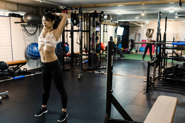mujeres maduras trabajando en cruz gimnasio - body care asian ethnicity body building toughness fotografías e imágenes de stock