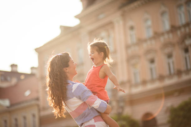 Your happiness is important to me. Mother playing with her daughter on city street. Copy space. Close up.