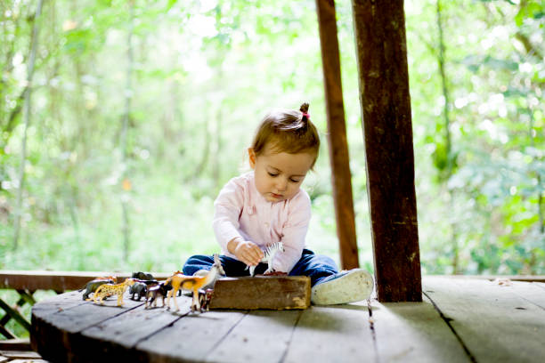 istock cute girl playing with toy animals 1036712026