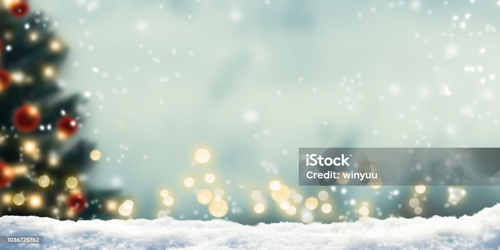 snow in front of wintery xmas background winter background with blurred xmas tree and bokeh lights Christmas Stock Photo