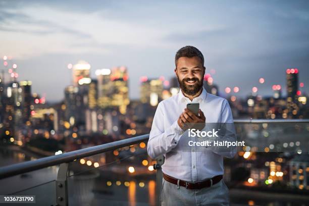 A Businessman With Smartphone Standing Against Night London View Panorama Stock Photo - Download Image Now