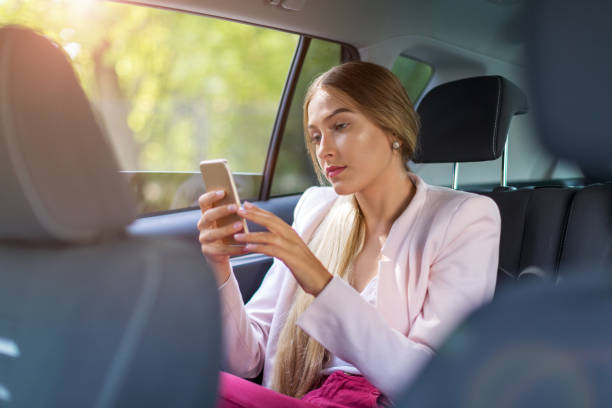 istock Woman with smart phone in a car 1036732022
