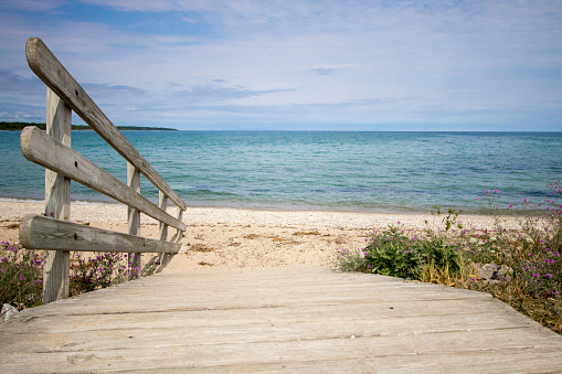 Wooden ramp to the blue waters of Lake Huron at the horizon. Color image in horizontal orientation with diminishing perspective.