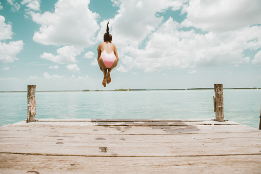 Woman jumping from pier