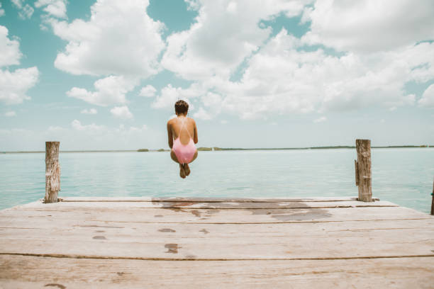 istock Woman jumping from pier 1036742742