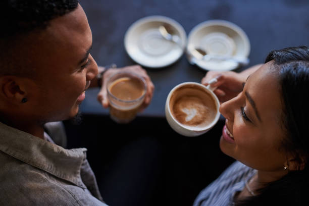 High angle shot of a young couple having coffee on a date in a cafe