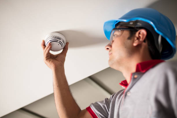 Man installing smoke detector stock photo