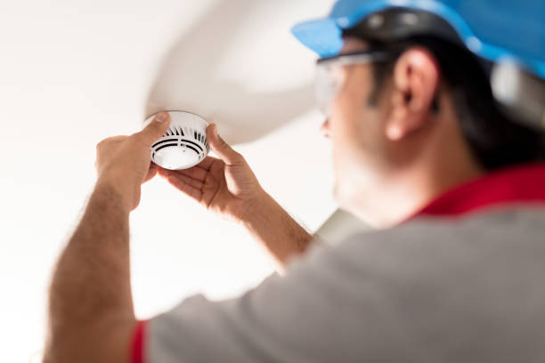 Man installing smoke detector stock photo