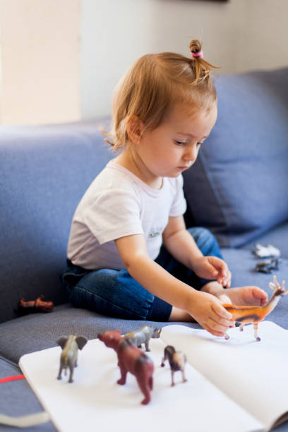 istock cute girl playing with toy animals 1036767050