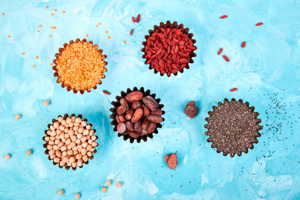 varios súper alimentos en un recipiente pequeño sobre fondo azul - quinoa sesame chia flax seed fotografías e imágenes de stock