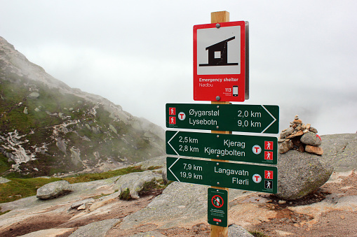Lysebotn, Norway - June 12, 2018: Signpost showing direction and distance to Kjeragbolten, a boulder wedged in the mountain's crevasse on the mountain Kjerag and a popular tourist destination.