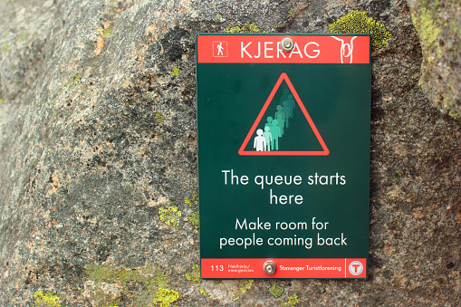 Lysebotn, Norway - June 12, 2018: Notice for the people who want to have a photo from Kjeragbolten. Long lines usually form with waiting time from a few minutes to over an hour.