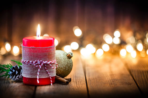istock Red Christmas candle on rustic wooden table 1036767904