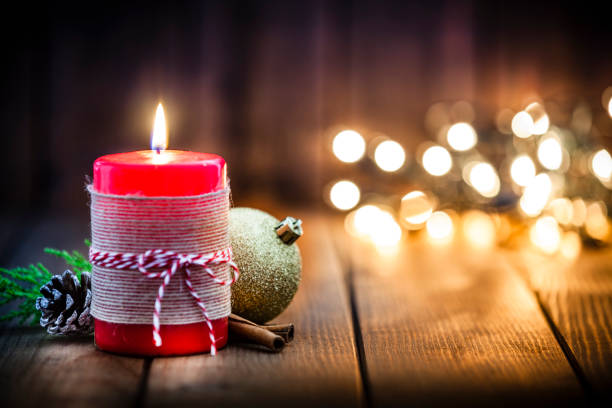 istock Red Christmas candle on rustic wooden table 1036768498