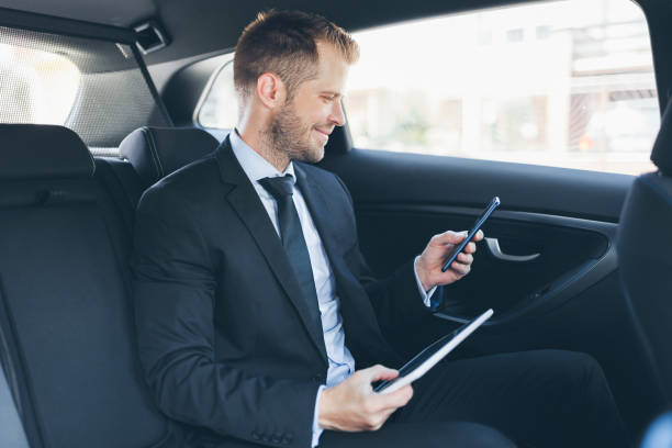 istock Executive businessman at the back of car using a mobile phone 1036774250
