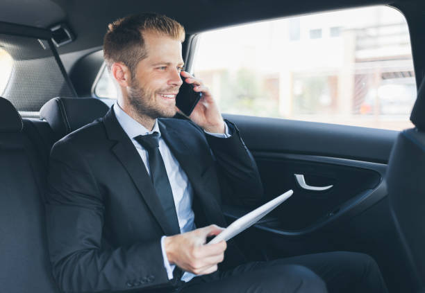 istock Executive businessman at the back of car using a mobile phone 1036774344