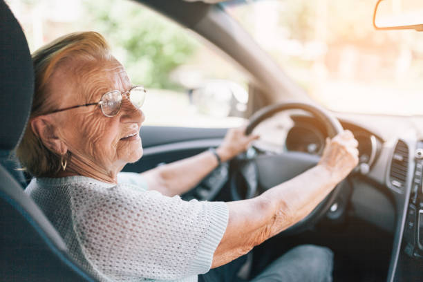 Elderly woman behind the steering wheel Elderly woman behind the steering wheel of a car drivers license photos stock pictures, royalty-free photos & images
