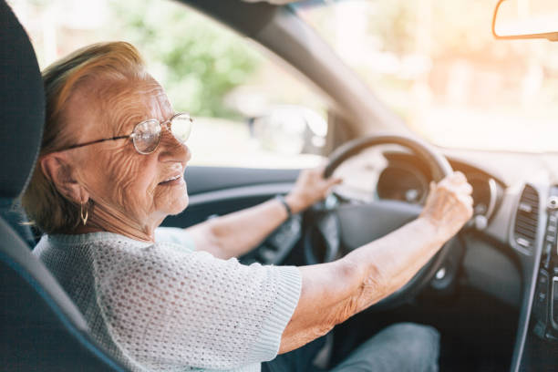 Elderly woman behind the steering wheel Elderly woman behind the steering wheel of a car motor living stock pictures, royalty-free photos & images