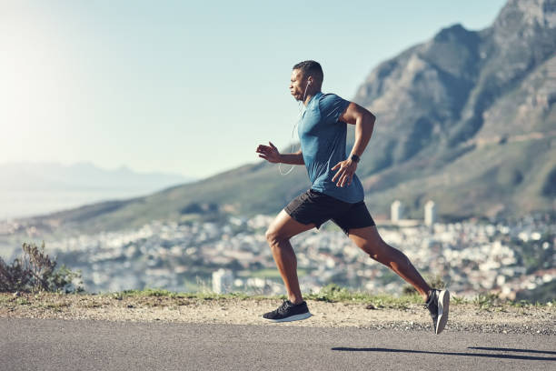 Running is one of the best ways to stay fit Shot of a young handsome man running outdoors running stock pictures, royalty-free photos & images