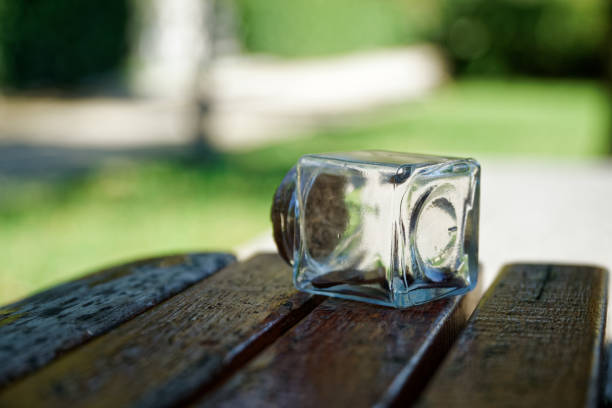 garrafa com moedas fica em um banco do parque, frasco transparente - transparent ideas lid glass - fotografias e filmes do acervo