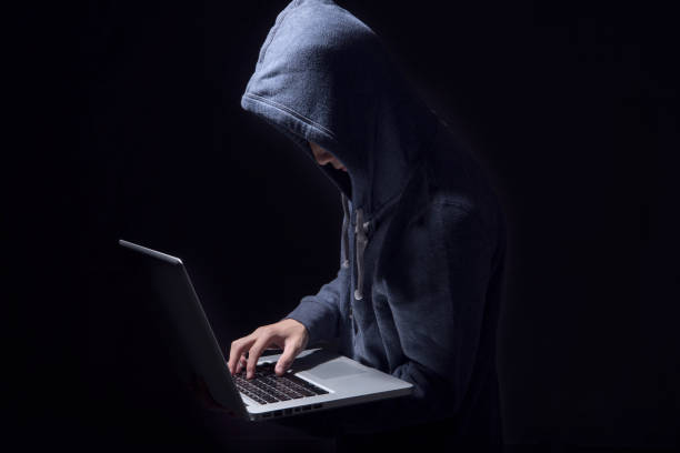 istock hacker in darkness the access to steal information and infect computers and systems. concept of hacking and cyber attack. 1036788094