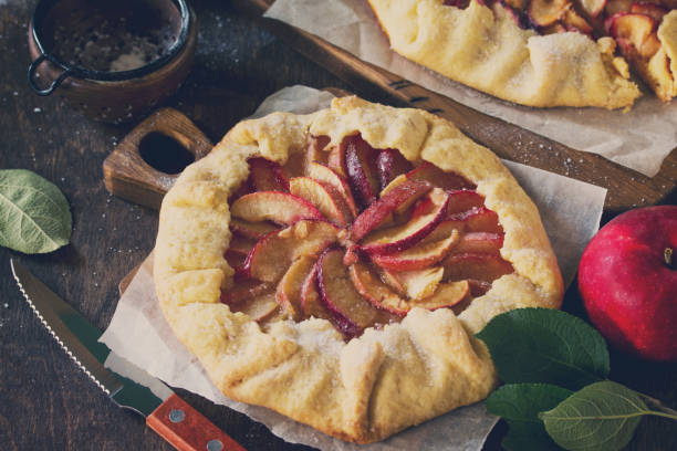 istock Autumn Bakery. Galette with Apple on a wooden kitchen table. Toned image. 1036799290