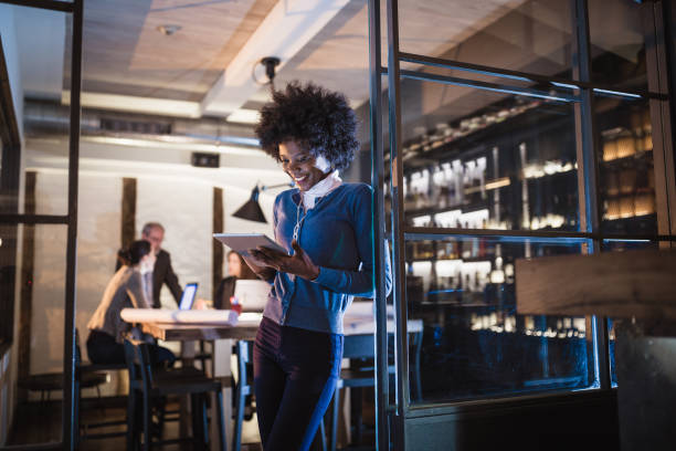 Young African-American woman architect using digital tablet in front of architecture studio Female Leaders. Young African-American woman architect using digital tablet in front of architecture studio. african american architecture stock pictures, royalty-free photos & images