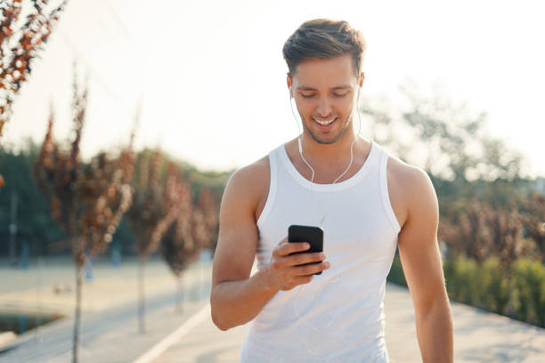 istock Young handsome runner with smart phone and earphones outside 1036804942