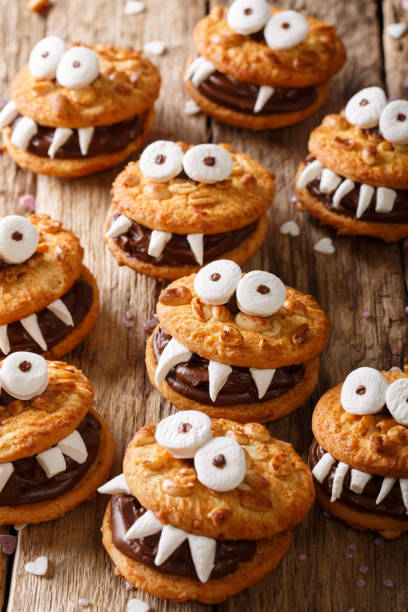 istock Halloween food: monsters of nutty cookies with chocolate cream close-up. vertical 1036809268